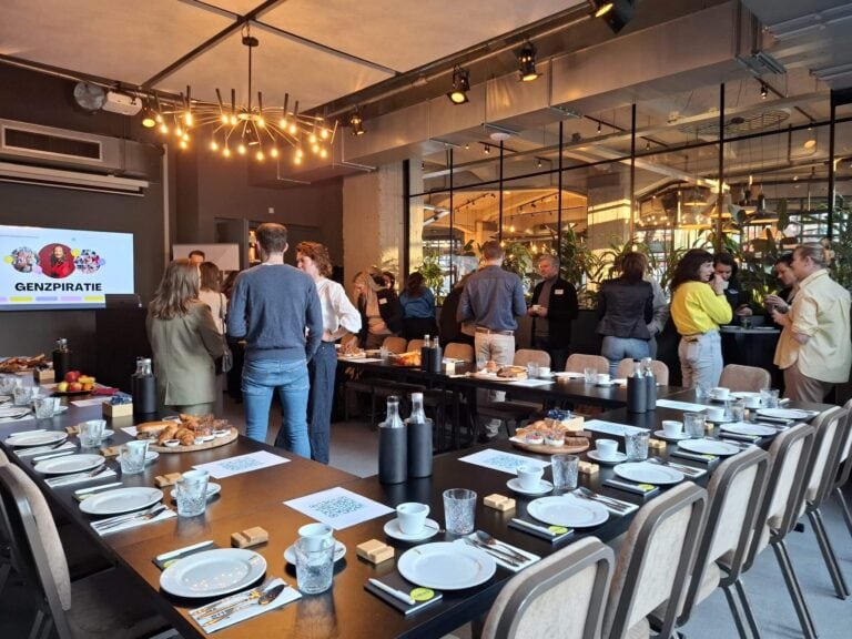 Samenstelling van mensen tijdens een bedrijfsbijeenkomst of netwerkevent in een modern, industrieel interieur met brunchtafels en natuurlijke lichtinval.