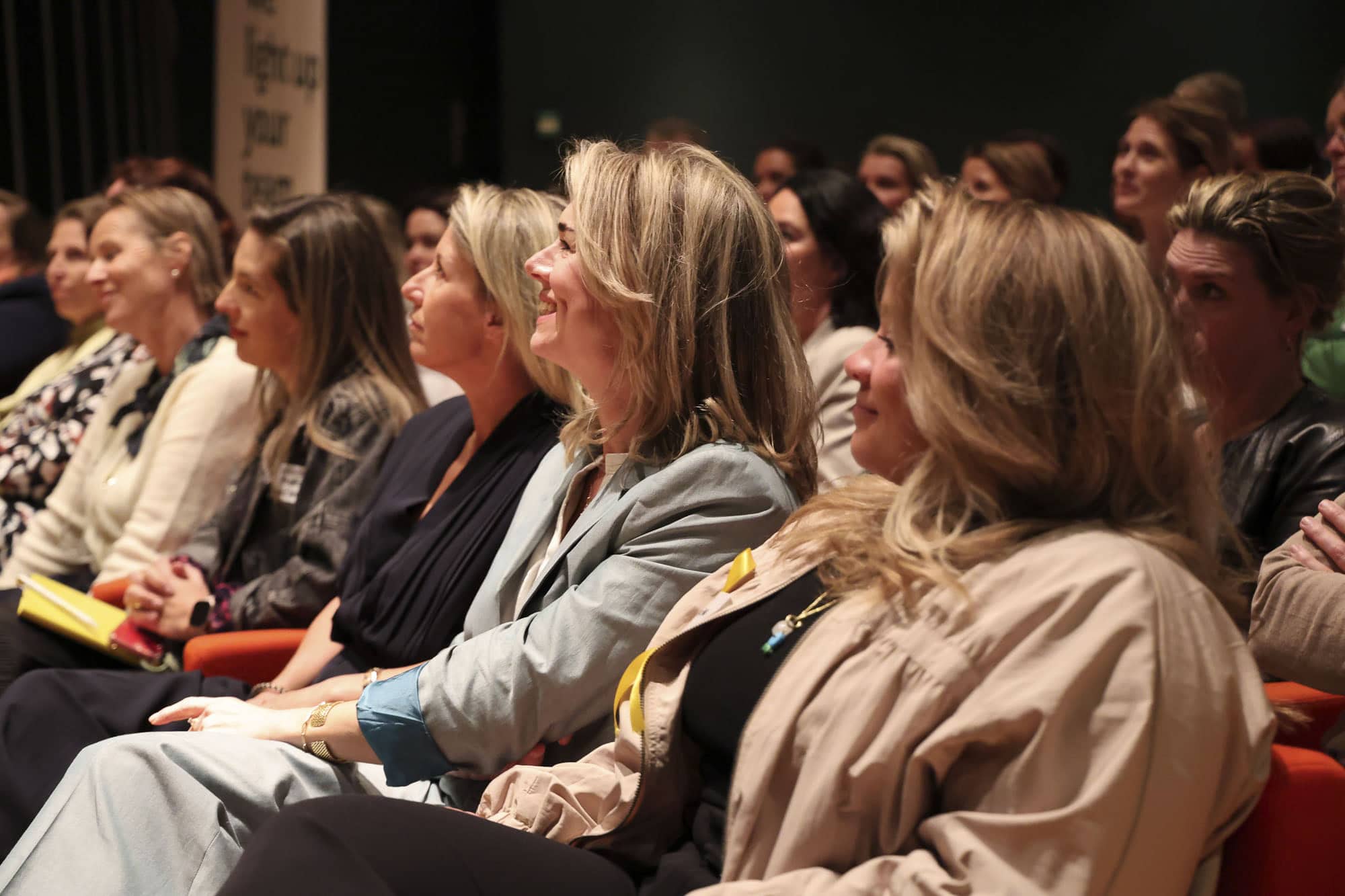 Stefanie Kollen, founder LICHT op een inspirerende netwerkevent, zittend in de zaal tijdens een presentatie of conferentie, met focus op professionele groei en succesvolle connecties.