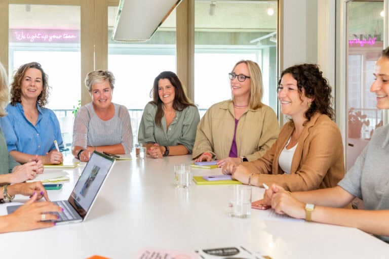 Krachtige samenwerking vrouwen team bijeenkomsten in modern kantoor, inspirerend en energiek, met focus op team building, inclusiviteit en professionele groei.