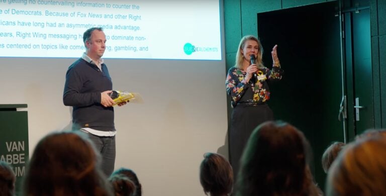 Kunstmatige verlichting, presentatie, vrouw met microfoon, publiek, zakelijke evenement.