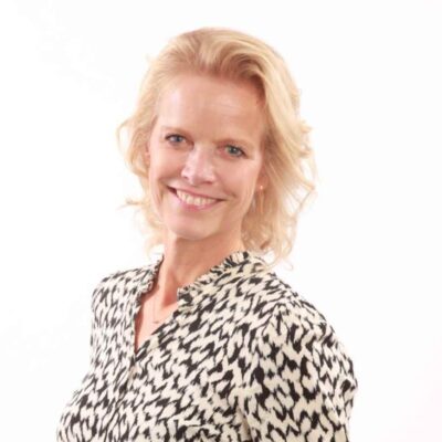 Blonde vrouw glimlachend in bloes met dierenprint, professioneel portret LICHT fotografie.