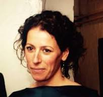 Verzorgde portretfoto van een vrouw met donker gekruld haar, professionele uitstraling, portret in warme sfeer, geschikt voor zakelijke en creatieve content in Nederland.